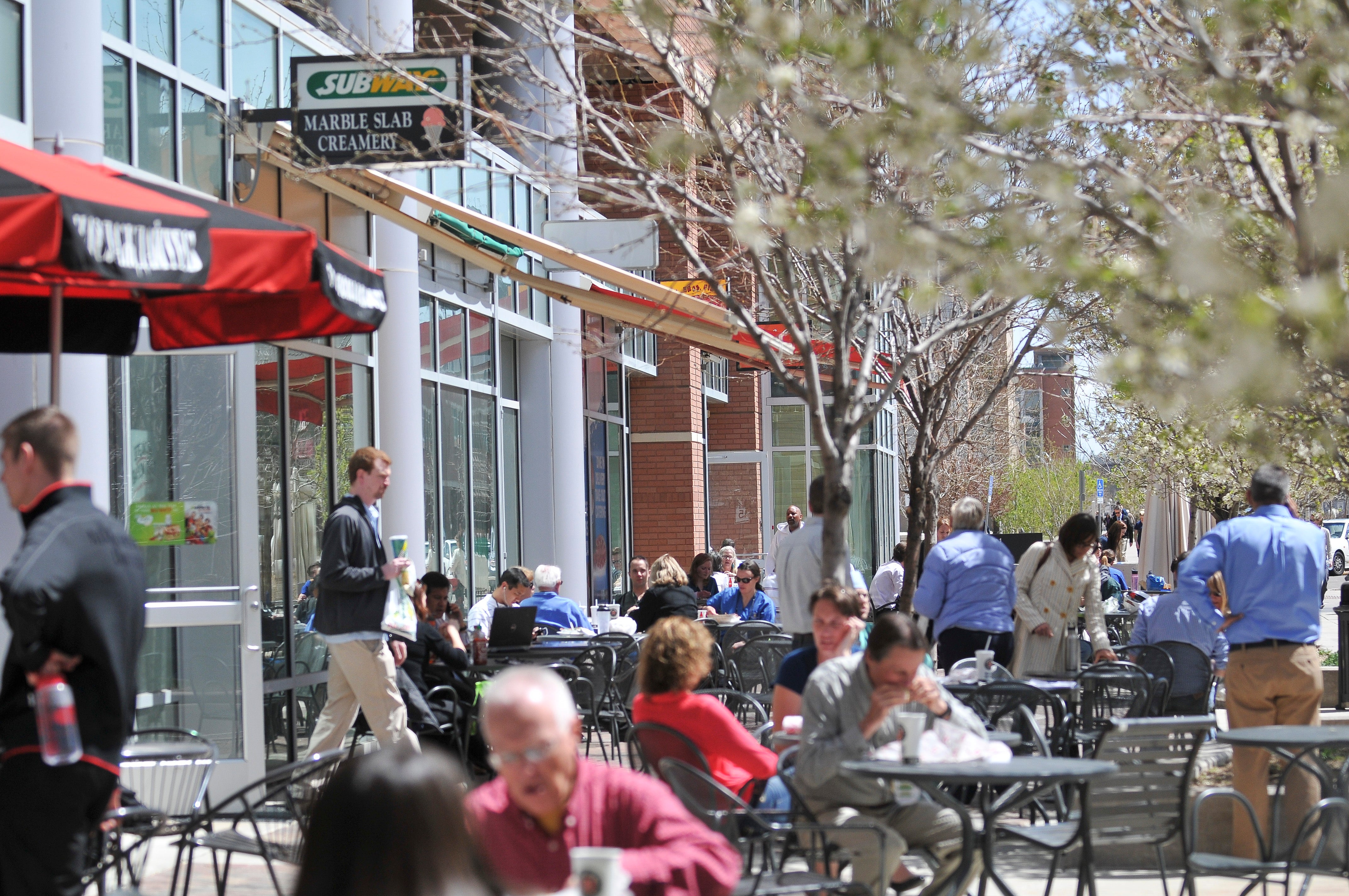 People dining and walking outside of a building